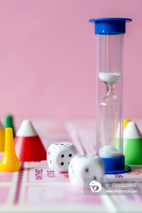 concept of board games. Dice, chips and cards on a pink background