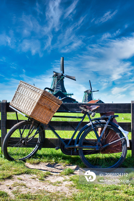 Bicycle with windmill and blue sky background. Scenic countryside landscape close to Amsterdam in the Netherlands.