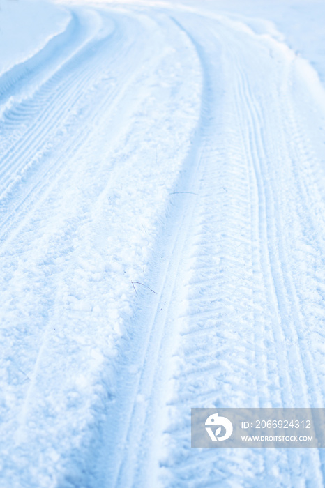 Tread texture of car wheels on snow. Winter road in January, December. Rural area and background of tractor tracks in the snow