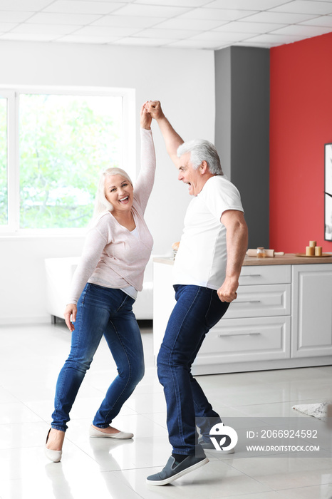 Happy mature couple dancing at home