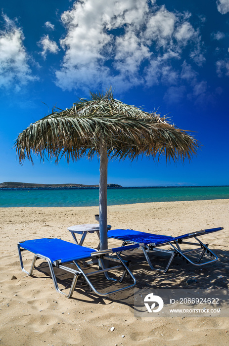 Paros island, Cyclades, Greece. Straw umbrellas and beach loungers on Golden Beach.