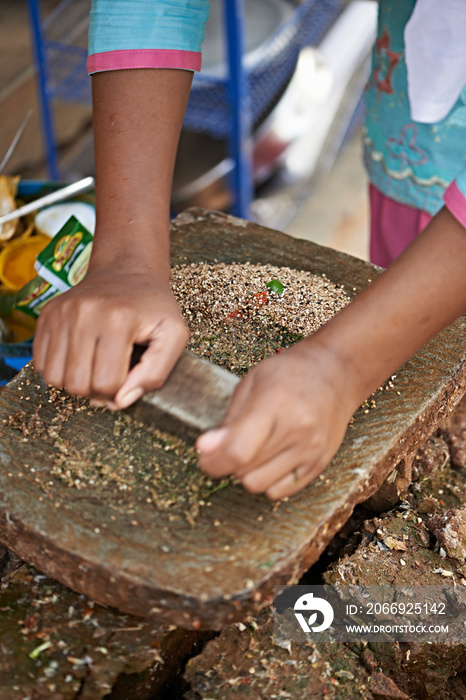 Female market traders hands grinding spices, Thamel, Kathmandu, Nepal