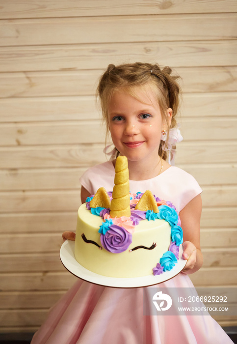 girl holding a cake in the form of a Unicorn