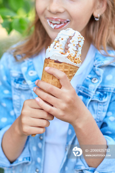 Cute girl liccking and eating italian ice cream cone while resting in park on summer day