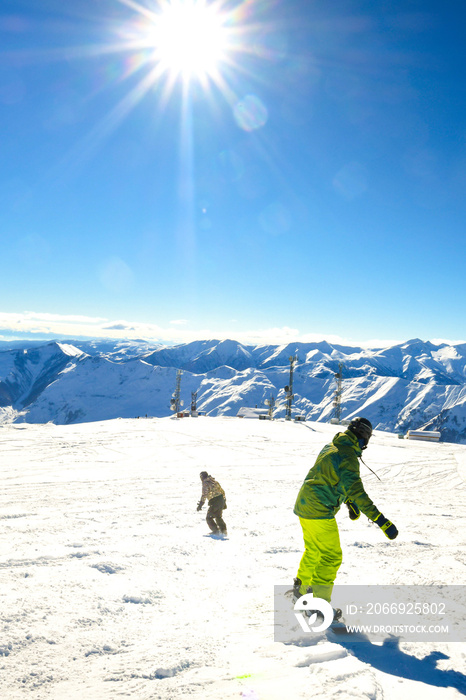 two friends buddies snowboarders back view ski downhill on holiday in ski resort have fun together in mountains