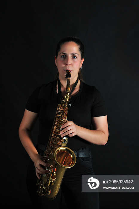 Young girl plays jazz music on saxophone