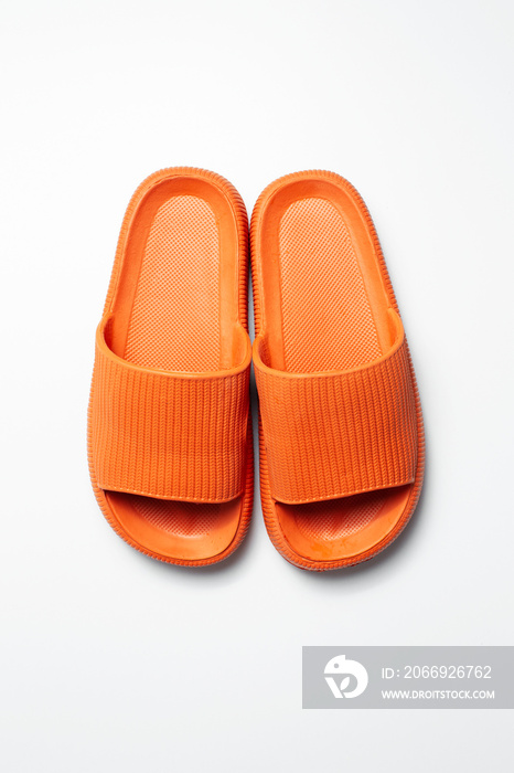 Top view of pair of orange slippers isolated on white background.