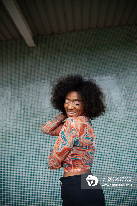 Young curvy woman with vitiligo posing in front of fun tiled wall