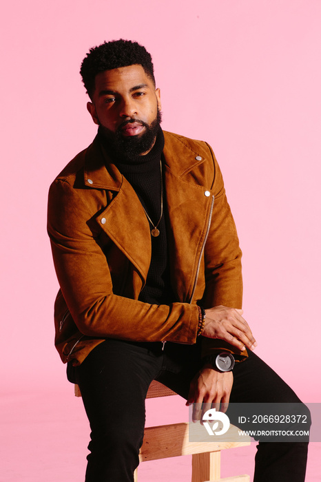 Stylish, handsome and cool African American man with beard, isolated on pink studio background