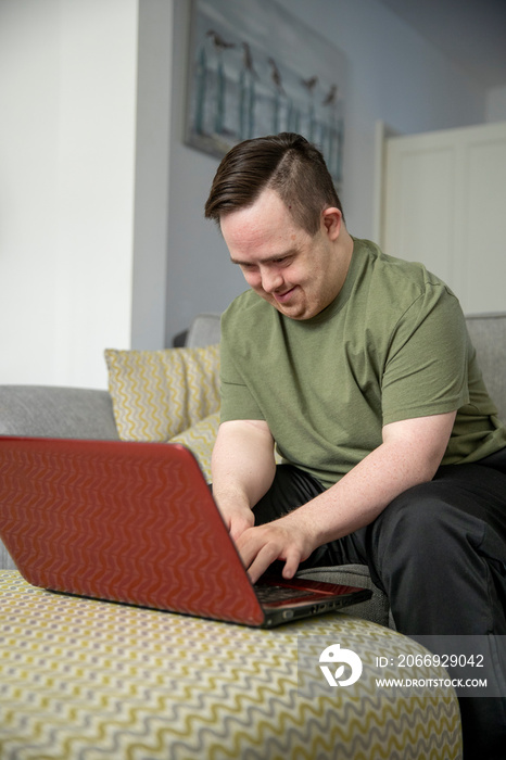 Man sitting on sofa and using laptop