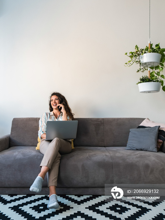 Cheerful woman talking on phone at home stock photo