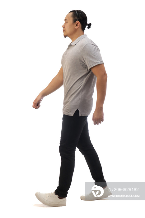 Asian man wearing casual grey shirt black denim and white shoes, walking forward, side view, happy confidence expression. Full body portrait isolated