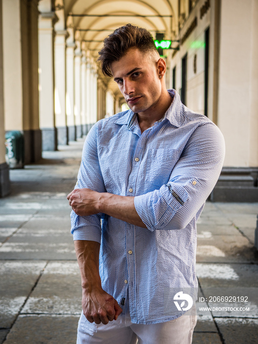 One handsome young man wearing shirt, in city setting