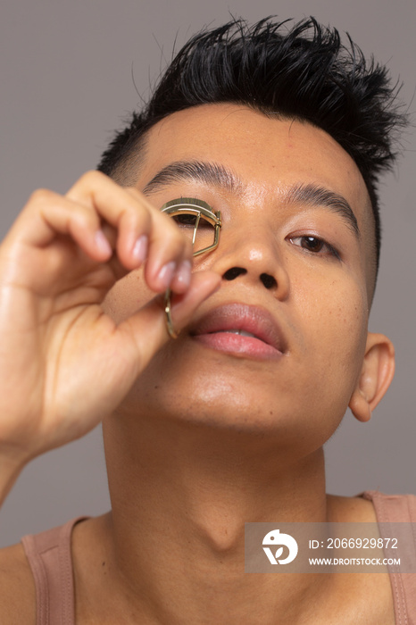 Close-up of person curling eyelashes with curler