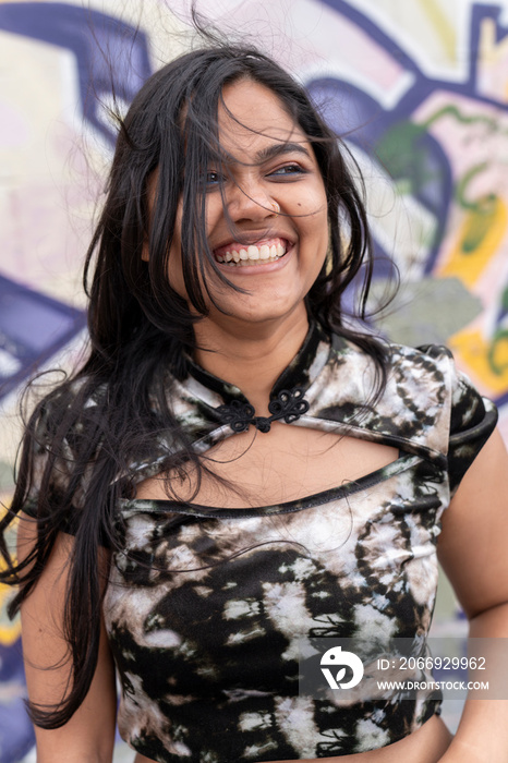 Portrait of young woman against graffiti wall