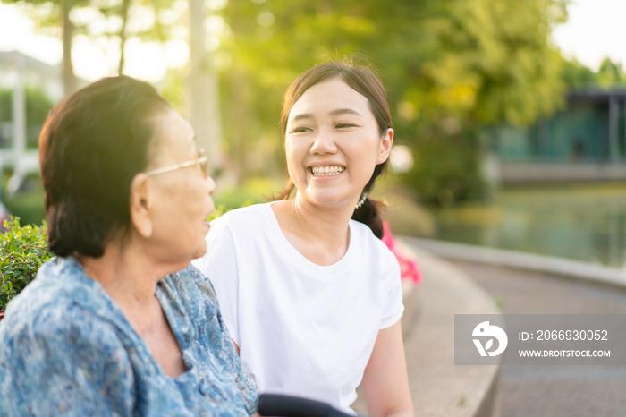 Asian woman taking care of elder Asian woman, age almost 90 years old in a park close up with copy space. Nursing an old people for their wellness, wellbeing and good health.