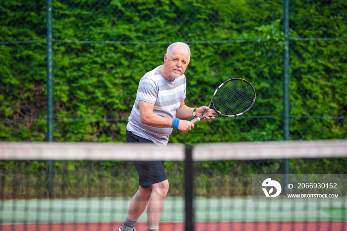 Portrait of senior man playing tennis in outside, retired sports, sport concept