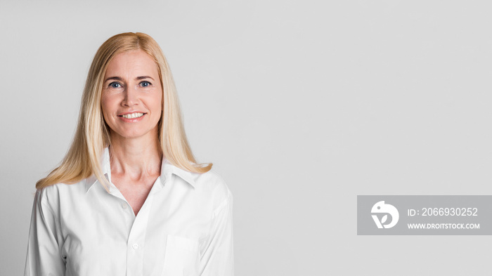 Smiling middle-aged woman looking at camera at studio