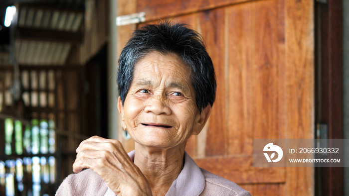 Asian elderly native woman smiling, laugh with happy in countryside. Senior female have relaxing moment in morning. Concept of people rural lifestyle, Thailand.