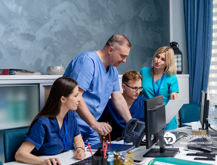 Medical team discussing diagnosis in office. Men and women medics.