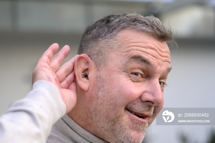 Middle age man has a hearing aid