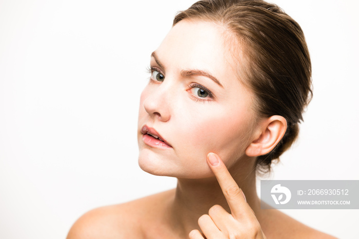 Caucasian woman who checks her skin. acne treatment.