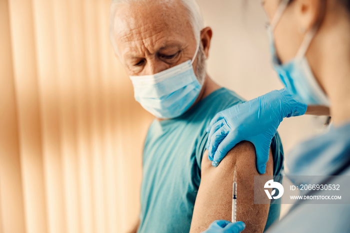 A senior man getting covid 19 vaccine in hospital.