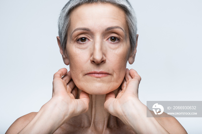 middle aged woman looking at camera isolated on grey