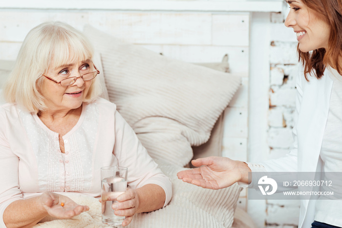 Pleasant elderly woman taking pills