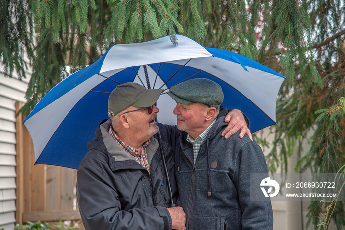 Gay married senior couple in love under their umbrella.