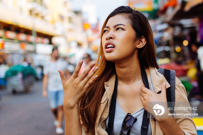 Young dissatisfied ethnic woman waving with hand unhappy with hot climate of tropical city