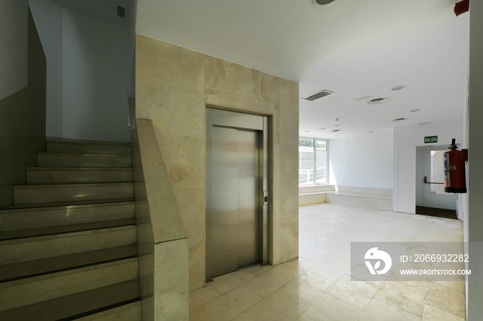 Hall of a residential building with elevator and marble stairs