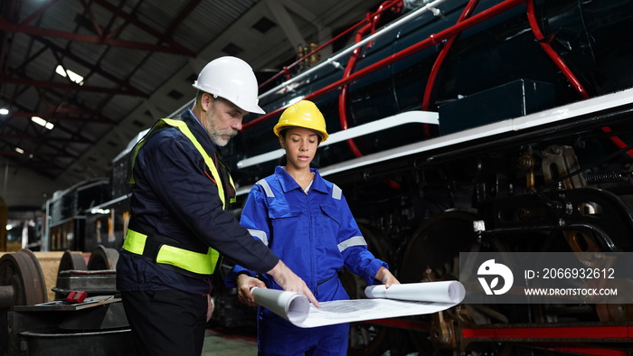 Group of apprentices with instructor at railway engineering facility. Teacher talking to apprentices at railway engineering facility