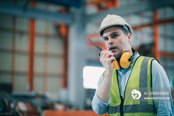 Industrial worker in factory site he communicating with a walkie talkie call working professional.