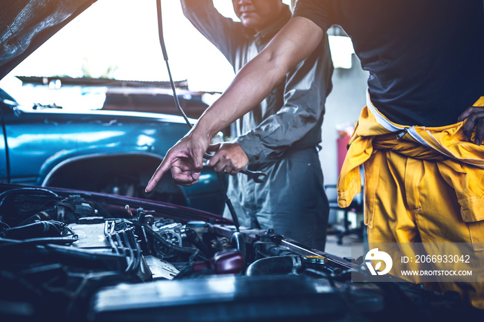 technician working on checking and service car in  workshop garage; technician repair and maintenance engine of automobile in car service.