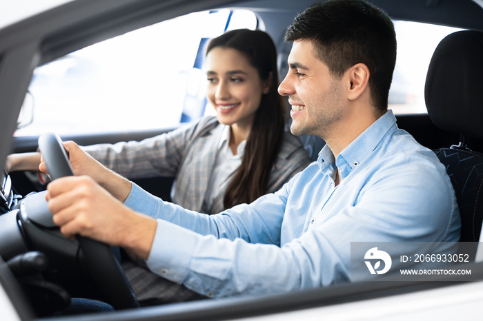 Wife And Husband Choosing Car In Dealership Shop