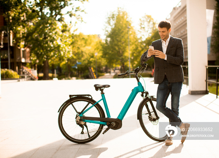 Young businessman on the ebike using mobile phone