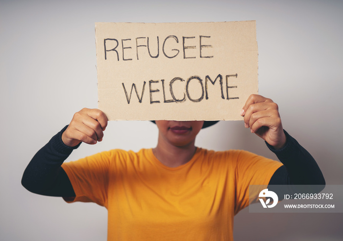 Woman holding pieces of paper with words Refugee Welcome message for help people concept NO WAR Russia and Ukraine