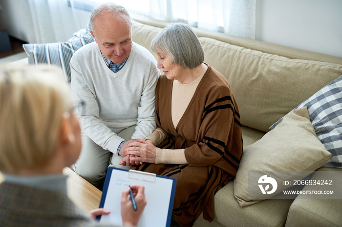 Portrait of nice senior couple visiting psychologist sharing problems in therapy session