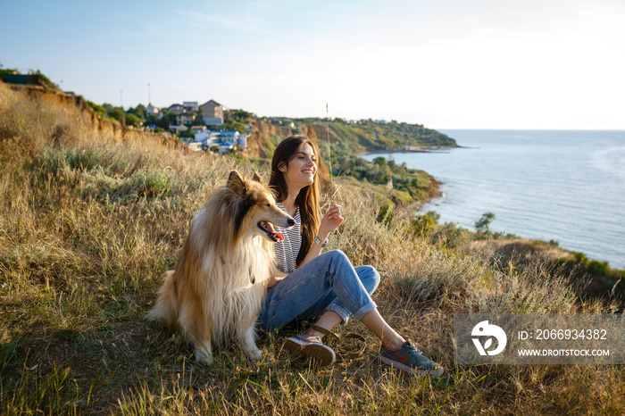 young woman and elderly dog walk in the countryside