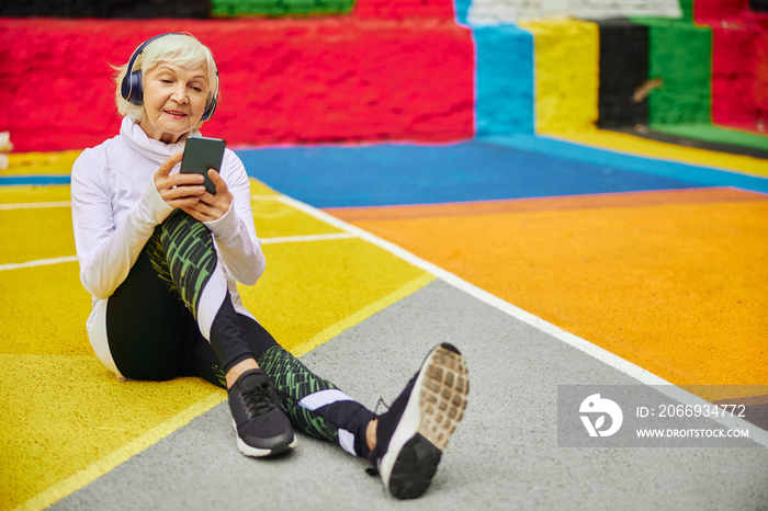 Old cheerful lady on a colourfull square outdoors