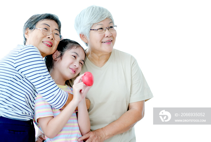 Two elderly women with young children hug together with smiling and all look to right side. Image is isolated on white background with copy space.