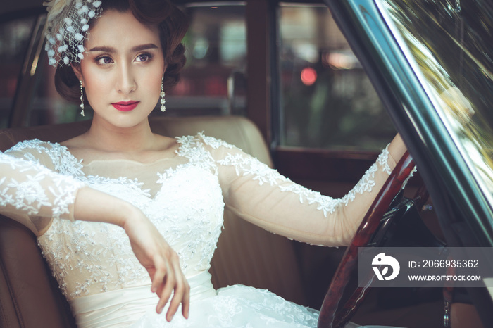 Portrait of young asian woman wearing a white dress with classic car. Concept beauty and fashion retro style