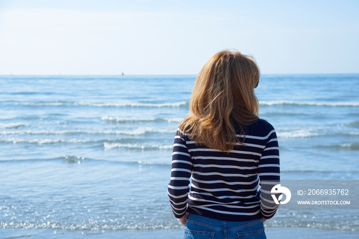 Rear view shot of woman standing on the beach