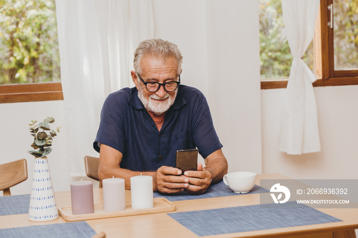 Senior elder old man happy to use smartphone watching or video calling at home