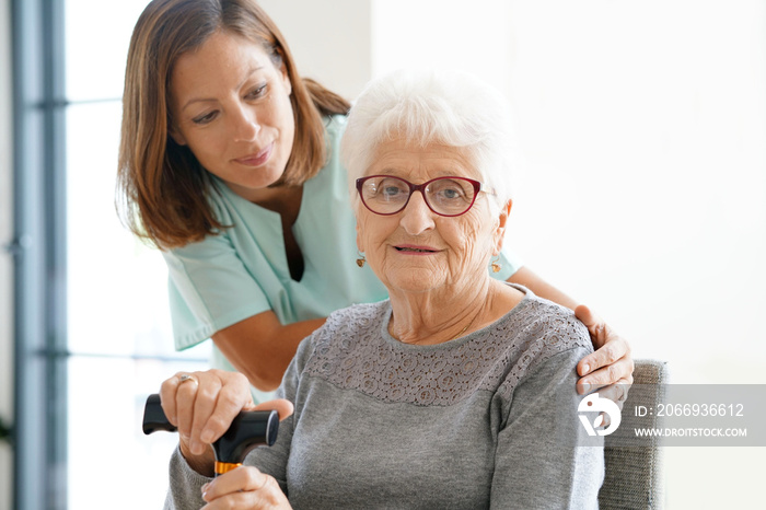 Nurse visiting old woman at home