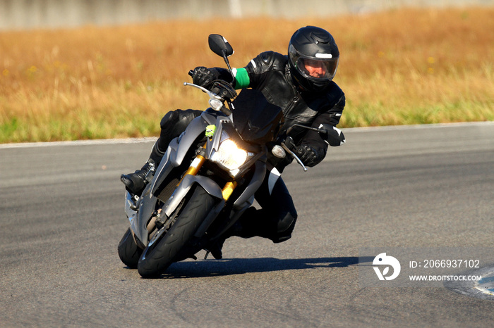 A biker in combination to cook on a motorcycle in a bend on a circuit