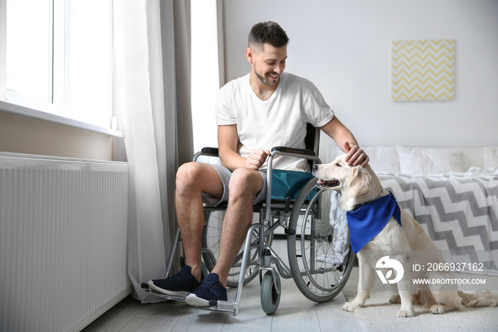 Man in wheelchair with service dog indoors