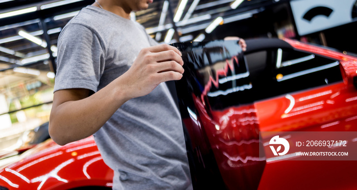 Applying tinting foil on a car window in a auto service