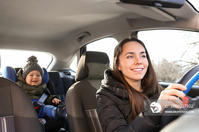 Woman driving car with her son buckled in baby seat